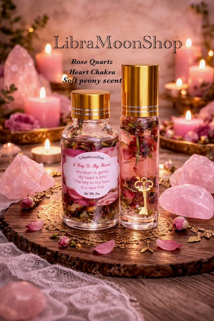 Two bottles of LibraMoonShop ritual oils with rose quartz and candles on a wooden surface.