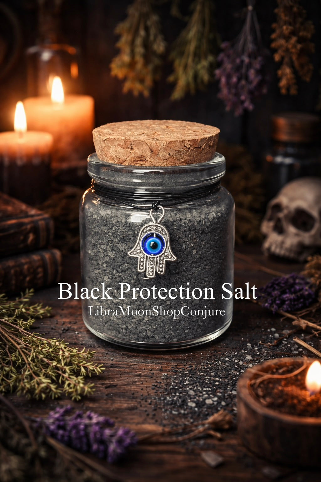 Jar of black protection salt with a cork lid on a dark background with candles and herbs.